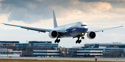 Asiana Airlines' Boeing 777 aircraft flying over a runway.